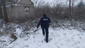 Policjant służby prewencyjnej sprawdza pustostany w porze zimowej