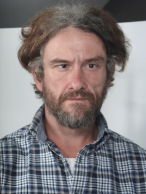 zdjęcie przedstawia mężczyznę zaginionego Marcina Osiak. Mężczyzna ma jasna cerę, włosy średniej długości  lekko siwiejące oraz brodę. Ubrany jest w koszulę w kratkę koloru niebiesko-białego