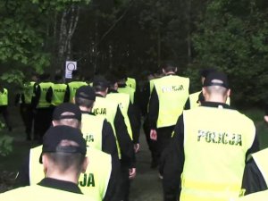 zdjęcie poglądowe przedstawiające kordon policjantów wchodzących do lasu